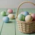Colorful speckled Easter eggs in a wicker basket on a pastel green wooden table Royalty Free Stock Photo