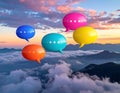 Colorful speech bubbles hover over a mountain range shrouded in clouds Royalty Free Stock Photo