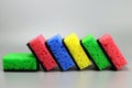 Colorful sponges, Washcloths for cleaning or washing dishes in a row on a gray background