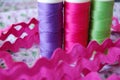 Extreme closeup of colorful spools of thread in purple, pink and green