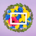 Colorful spring circular flower arrangement. Blue, yellow and pink flowers and green leaves against purple background. Minimal Royalty Free Stock Photo