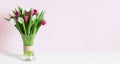 Colorful spring tulips in a vase on a white table Royalty Free Stock Photo