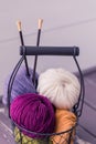 Colorful spring wool yarn in an iron basket with wooden knitting needles Royalty Free Stock Photo