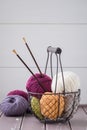 Colorful spring wool yarn in an iron basket with wooden knitting needles Royalty Free Stock Photo