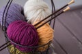 Colorful spring wool yarn in an iron basket with wooden knitting needles Royalty Free Stock Photo