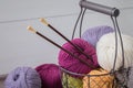 Colorful spring wool yarn in an iron basket with wooden knitting needles Royalty Free Stock Photo
