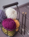 Colorful spring wool yarn in an iron basket with wooden knitting needles and scissors Royalty Free Stock Photo