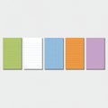 Colorful stack of notepads arranged artfully on a light background, showcasing creativity and organization in a workspace setting Royalty Free Stock Photo