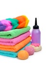 Colorful stacked spa towels, bath bombs and shampoo bottle isolated on white Royalty Free Stock Photo