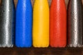 Colorful stainless thermos bottles on a wooden table sprayed with water.