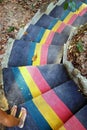 Colorful stairs in jungle and two feet of woman in sandals, top view. Royalty Free Stock Photo