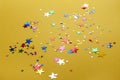 Colorful stars confetti on yellow background. Carnival, party decor. Christmas decoration
