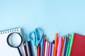Colorful stationary school supplies on blue trending background with a copy space