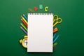 Colorful stationary school supplies on green background