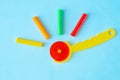 Colorful sticks plasticine with rotary cutter knife on a blue background, multicolored modeling clay.