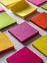 Colorful sticky note pads arranged in a neat grid pattern on a textured white surface creating a vibrant and organized workspace Royalty Free Stock Photo