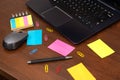 Creative Chaos: Colorful Sticky Notes and Desk Essentials on Wooden Surface