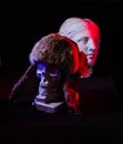 A colorful still life of an artificial skull and a female face statue. Royalty Free Stock Photo