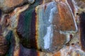 Colorful stone surface closeup photo with wet stain. Stone wall texture. Big rocks with moss and rust. Geology backdrop Royalty Free Stock Photo