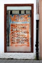 Colorful store window welcome sign to people of all types religions beliefs sexes cultures ages colours and sizes