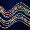 Colorful strand of festive beads forming a wavy pattern against a dark background Royalty Free Stock Photo