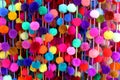 Colorful strands of pom-poms hang at a market Mexico.