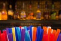 Colorful Straws and Blurred Bottles of Spirits and Liquor in the Bar Royalty Free Stock Photo