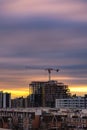 Colorful streaky sunset sky behind a large crane on top of construction site Royalty Free Stock Photo