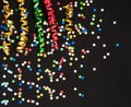 Colorful streamer and confetti on black paper Royalty Free Stock Photo