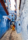 Colorful street of the Blue City with tourists and local people in Chefchaouen Medina, Morocco Royalty Free Stock Photo