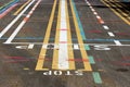 Colorful street line testing site with multiple lines in various colors and shapes with letters painted on paved surface