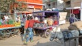 Colorful street scene at the vegetable market with food stalls and a donkey