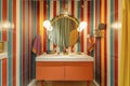 Colorful Striped Bathroom Interior with Double Vanity and Round Mirror