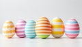 Colorful striped easter eggs arranged in a row on a white background Royalty Free Stock Photo