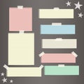 Colorful striped paper, copybook, notebook sheets for note or message stuck with sticky, adhesive tape, stars on dark Royalty Free Stock Photo