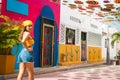 Colorful stroll: Latina woman exploring the vibrant streets of Riohacha, Colombia