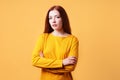 Colorful studio portrait of confident young woman with her arms folded