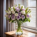 Colorful stylish flower arrangement with lavender and white roses in a glass vase on the table by a window. Beautiful Royalty Free Stock Photo