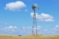 Colorful Summer blue sky with white clouds and a Kansas Windmill in a Pasture.