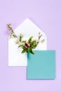 Colorful summer flowers in envelope and turquoise sheet on violet background.