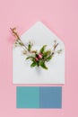 Colorful summer flowers in envelope and turquoise sheets on pink background.