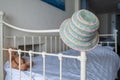 Colorful summer hat on bed frame with teddy bear plush toy Royalty Free Stock Photo
