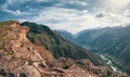 Colorful summer landscape with silhouettes of big rocky mountains and epic deep gorge with river.The edge of a rocky cliff with a