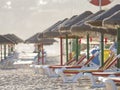 Colorful sun beds under straw umbrellas on the beach Royalty Free Stock Photo