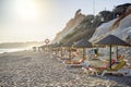 Colorful sun beds under straw umbrellas on the beach