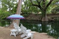 Colorful Sun Umbrella and White Chairs Along Blanco River Royalty Free Stock Photo