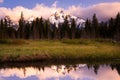 Colorful sunrise and clouds over snowy mountains reflected in a pond Royalty Free Stock Photo