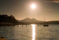 Colorful sunrise at coastal, abandoned wharf. Island with stronghold at horizon. Royalty Free Stock Photo