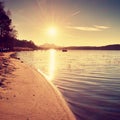 Colorful sunrise at coastal, abandoned wharf. Island with stronghold at horizon. Royalty Free Stock Photo