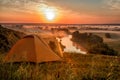 Colorful sunrise over tourist tent in camp among meadow Royalty Free Stock Photo